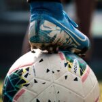 A football boot resting on a football