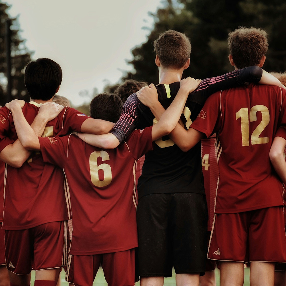 players in read shirts huddle