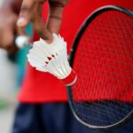 Man holding badminton racket and shuttle